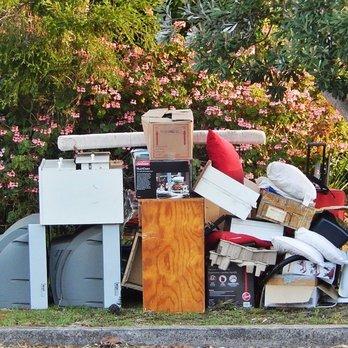 picture of junk including plastic storage containers pillows dressers and cardboard boxes