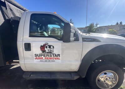 Side view of Superstar Junk Removal truck showing logo on passenger door in Sacramento