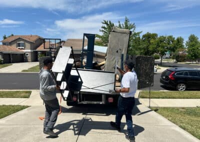 Junk removal worker carrying household items during estate cleanout in Sacramento